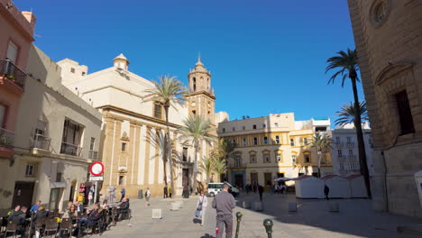 Sunny-plaza-with-palm-trees-and-historical-church-in-Cádiz