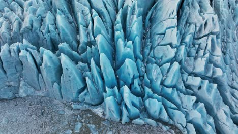 Aerial-view-over-textured-ice-formations-of-a-glacier-in-Iceland,-at-dusk