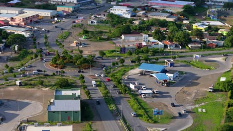 Wide-angle-aerial-establishing-view-of-traffic-circle-and-gas-station-on-Caribbean-island