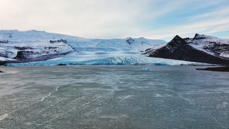 Vista-Aérea-Del-Paisaje-De-Un-Glaciar-Con-Formaciones-De-Hielo-Texturizadas,-En-Islandia,-Al-Atardecer