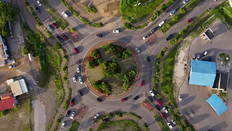Aerial-top-down-rotate-of-tropical-roundabout-as-cars-enter-and-exit-at-rush-hour