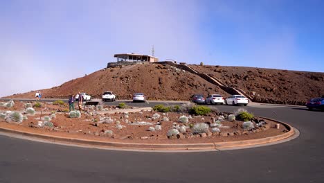 The-top-Summit-of-Haleakala-National-Park-in-Maui,-Hawaii,-Haleakala-visitor-center-pictured-above-the-clouds-before-sunset
