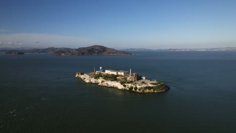 Aerial-view-tilting-toward-the-Alcatraz-island,-golden-hour-in-San-Francisco,-USA