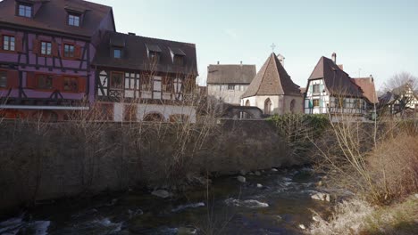 The-Weiss-river-flowing-through-the-traditional-half-timbered-french-village-of-Kaysersberg,-France