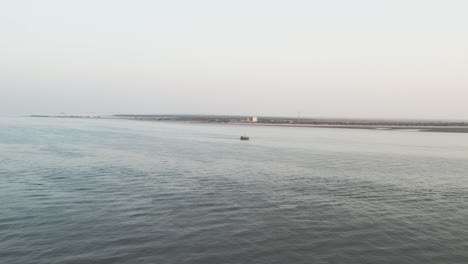 Aerial-view-of-a-lonely-boat-on-the-Arabian-Sea-at-dusk,-near-Karachi,-Pakistan