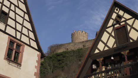 Charmante-Fachwerkhäuser-Mit-Burgturm-Im-Hintergrund-An-Einem-Klaren-Blauen-Himmel