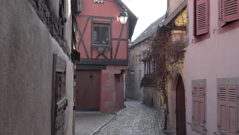 Scenic-small-cobblestone-streets-in-medieval-french-village-kaysersberg-with-half-timbered-architectural-buildings