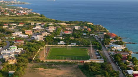 Establishing-aerial-of-football-soccer-field-on-coast-of-Caribbean-tropical-island