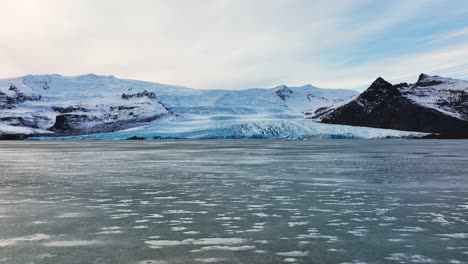 Vista-Panorámica-Aérea-De-Un-Glaciar-Con-Formaciones-De-Hielo-Texturizadas,-En-Islandia,-Al-Atardecer