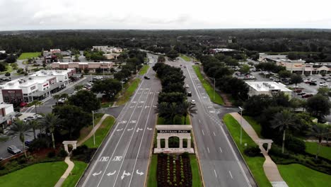 Luftaufnahme,-Die-Die-Straßen-Zeigt,-An-Denen-Autos-Vorbeifahren,-Weiße-Wolken,-Bäume-Auf-Der-Seite-Des-Schildes-Bartram-Park-Jacksonville