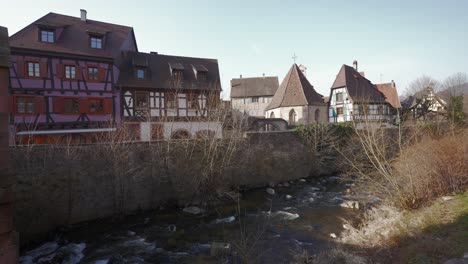 Touristic-medieval-town,-half-timbered-architecture-houses-and-river-flowing-in-kaysersberg,-France
