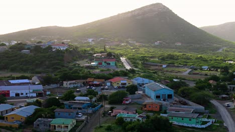 Lebhafte,-Farbenfrohe-Karibische-Häuser-Auf-Curaçao-Im-Schatten-Der-Wolken,-Während-Goldenes-Licht-Auf-Wunderschöne-Tropische-Hügel-Fällt