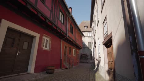 Empty-cobblestone-street-with-half-timbered-architecture-in-medieval-french-village-of-Kaysersberg,-France