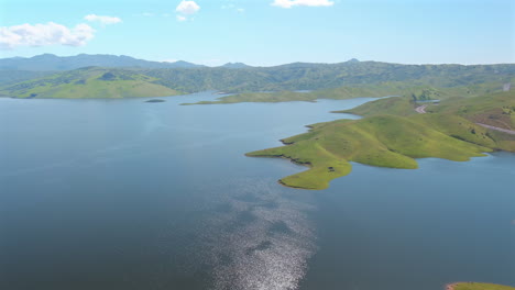 Aerial-pan-showing-the-green-hills-and-high-water-line-at-San-Luis-Reservoir-after-heavy-rains