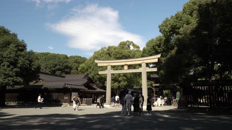 Touristen,-Die-An-Einem-Sonnigen-Nachmittag-Am-Meiji-Jingu-Nino-Torii-Tor-Vorbeigehen