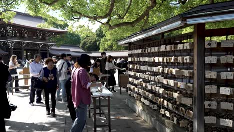 Visitors-Writing-Wishes-And-Prayers-On-Ema-Wooden-Plaques-At-Meji-Shrine