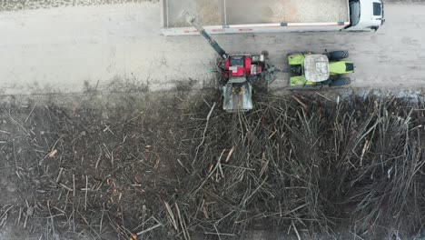 Aerial-view-of-hydraulic-crane-put-tree-branch-into-wood-chipper-unit