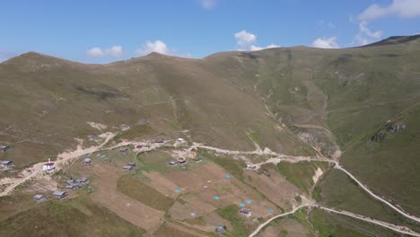 Drone-view-of-rural-settlement-Multat-plateau-at-the-foot-of-the-mountain,-dirt-land