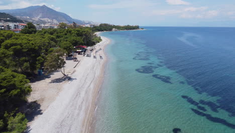 Eine-Drohne-Fliegt-Parallel-Zum-Strand-über-Der-Kleinen-Stadt-Xylokastro-In-Griechenland