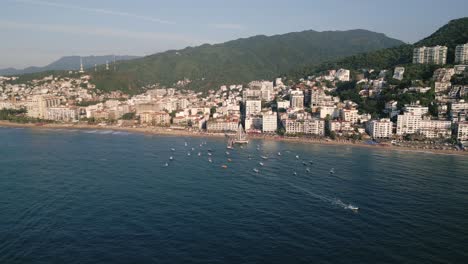 Aerial-of-Puerto-Vallarta-romantic-zone-pacific-coastline-of-old-town-in-Mexico-with-sailboat-moored-at-bay