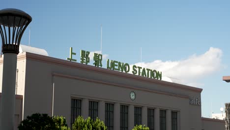 Edificio-De-La-Estación-De-Ueno-Con-Señalización-Verde-En-La-Parte-Superior-En-Un-Día-Soleado