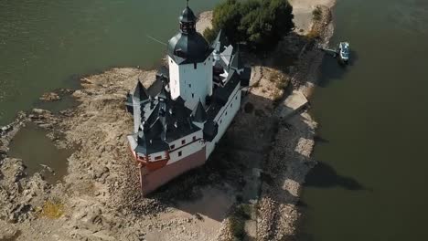 The-Pfalzgrafenstein-castle-rises-out-of-the-Rhine-River-in-this-orbiting-drone-shot