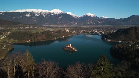Drone-Flies-Away-from-Lake-Bled,-Slovenia-to-Reveal-Forest