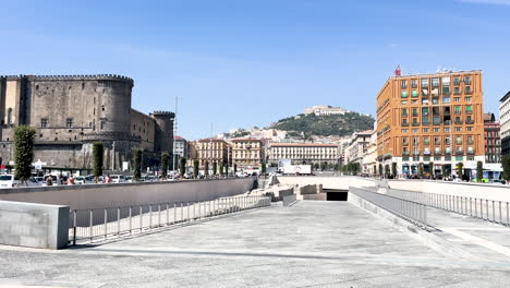 Castel-Nuovo---medieval-stone-castle-in-an-urban-setting,-surrounded-by-modern-streets-and-buildings-under-a-clear-sky-in-Naples,-Italy