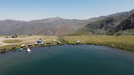 Caravan-images-by-the-fish-lake-at-the-top-of-the-mountain,-mountaineers-camping,-Drone-view