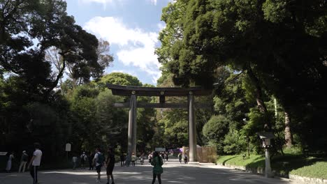 Besucher,-Die-Den-Weg-Entlang-Gehen,-Großes-Hölzernes-Torii-Tor,-Das-Zum-Meiji-Jingu-Schrein-In-Tokio-Führt