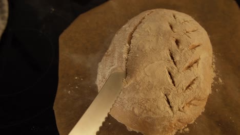 Scoring-a-fresh-loaf-of-homemade-sourdough-bread