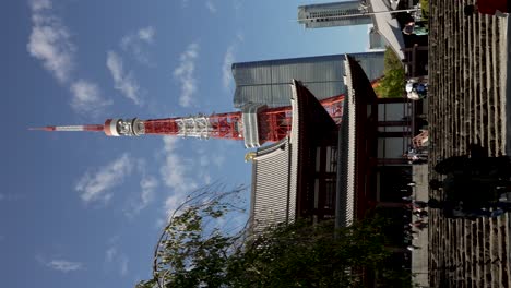 Visitantes-Subiendo-Escaleras-Hacia-El-Templo-Zojo-ji-Con-La-Torre-De-Tokio-Y-El-Edificio-De-Las-Colinas-Azabudai-Al-Fondo.