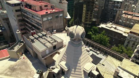 Aerial-orbiting-shot-over-Ariztía-Building-Rooftop-and-tower,-First-Skyscraper-in-Santiago-de-Chile