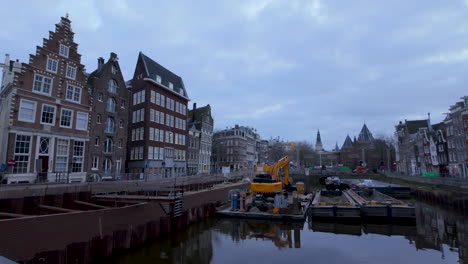 Trabajos-De-Construcción-De-Un-Canal-Con-Edificios-Tradicionales-Y-Una-Grúa-En-Ámsterdam.