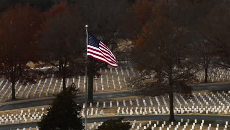 Drone-establishing-shot-of-waving-american-flag-on-large-Fayetteville-National-Cemetery,-Arkansas,-USA