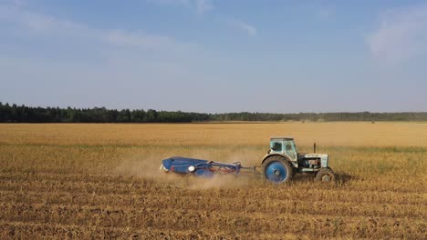 Farmer-use-old-soviet-built-tractor-to-harvest-garlic,-bright-summer-day