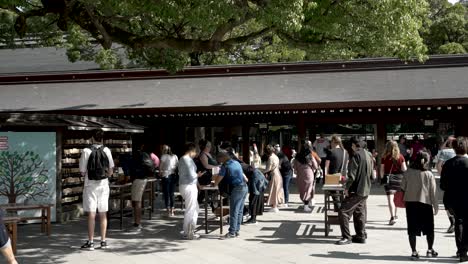 Tourists-Using-Bench-To-Write-Wishes-And-Prayers-On-Ema-Wooden-Plaques-At-Meji-Shrine