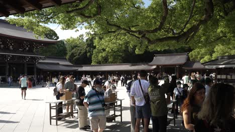 Visitors-Writing-Wishes-And-Prayers-On-Ema-Wooden-Plaques-At-Meji-Shrine-Courtyard