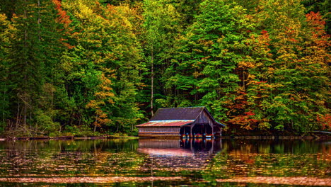 Timelapse-of-moving-water-on-a-tidal-lake-with-autumn-colored-forest-in-the-backdrop