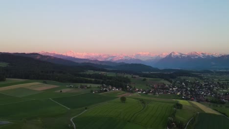 Aerial-of-rural-landscape-and-swiss-mountains-at-dusk