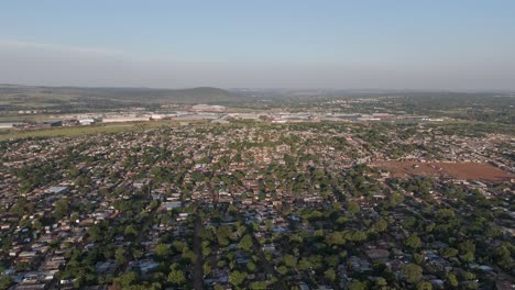 In-this-brief-4K-aerial-clip,-the-camera-takes-a-slight-right-turn,-revealing-the-vast-expanse-of-a-rural-township-adjacent-to-the-industrial-areas-of-Pretoria,-South-Africa