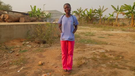 Retrato-De-Un-Feliz-Médico-Africano-Metiendo-La-Mano-En-El-Bolsillo-Del-Laboratorio-De-Batas-De-Pie-Y-Sonriendo-Frente-A-La-Cámara-En-El-Hospital-Clínico-De-Una-Aldea-Remota