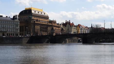 National-Theatre-Prague-and-traffic-over-the-Legion-bridge,-Vltava-river,-Czech-Republic