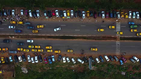 Von-Oben-Nach-Unten-Geschossene-Drohne-über-Verkehr-Und-Geparkten-Autos-In-Der-Stadt-Yaoundé,-Kamerun