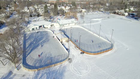 Aerial-view-of-outdoor-ice-hockey-rinks-and-community-centre-in-Winnipeg,-Canada,-4K