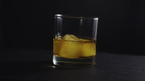 Vaso-De-Whisky-Girando-Sobre-Fondo-Negro
