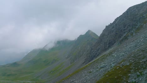 Inspirierende-Luftaufnahme-Im-Bergtal-In-Der-Nähe-Von-Klippe-Und-Gipfel-Mit-Nebligen-Wolken