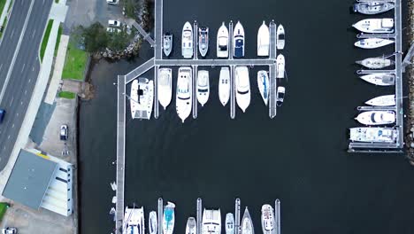 Drone-aerial-landscape-of-boat-wharf-dock-with-yachts-stationed-in-harbour-transport-marine-road-streets-Batemans-Bay-South-Coast-Australia