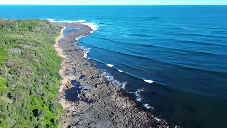 Drone-aerial-Broulee-beach-island-headland-coastline-with-waves-on-reef-point-surfing-break-Mossy-Point-South-Coast-tourism-travel-Australia