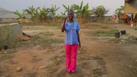 Afrikanische-Ärztin-Und-Krankenschwester-Mit-Stethoskop,-Die-In-Einer-Abgelegenen-Kleinen-Dorfkrankenhausklinik-Lacht-Und-Mit-Einer-Handbewegung-„Ich-Liebe-Dich“-Sagt